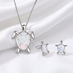 Set completo collana e orecchini tartaruga marina in opale su lenzuolo bianco