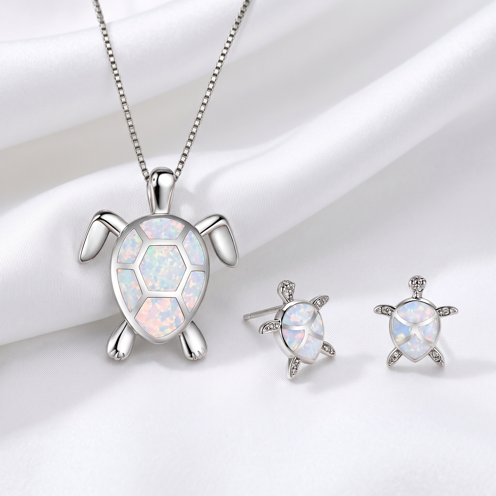 Set completo collana e orecchini tartaruga marina in opale su lenzuolo bianco